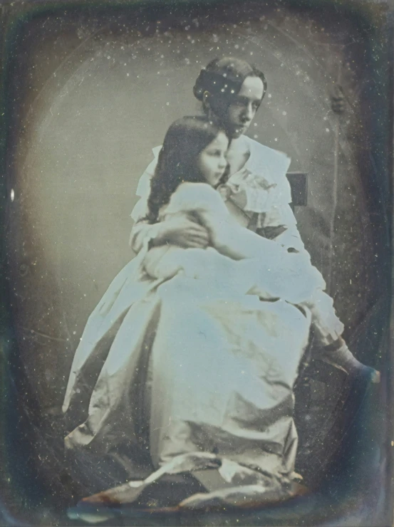 an old po of a man and a woman with hair in their eyes, sitting in a bed