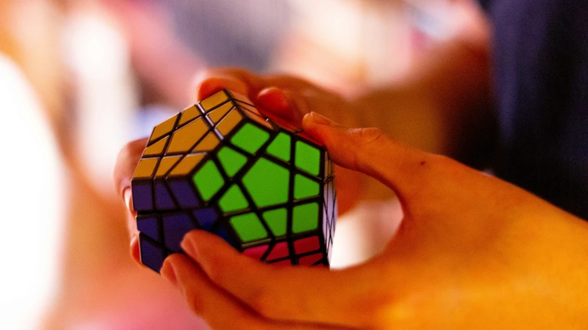 a person holding a colorful cube with one end