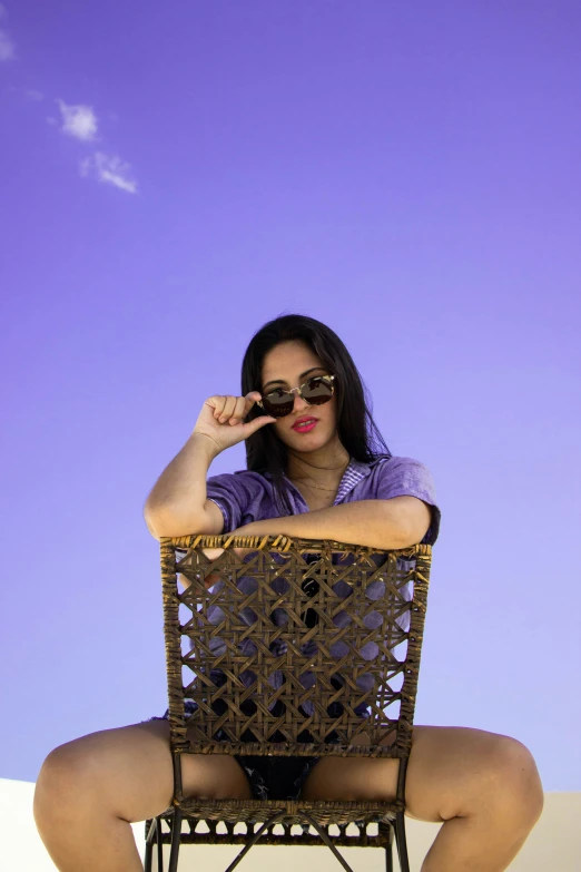 a woman with sunglasses sitting in a chair