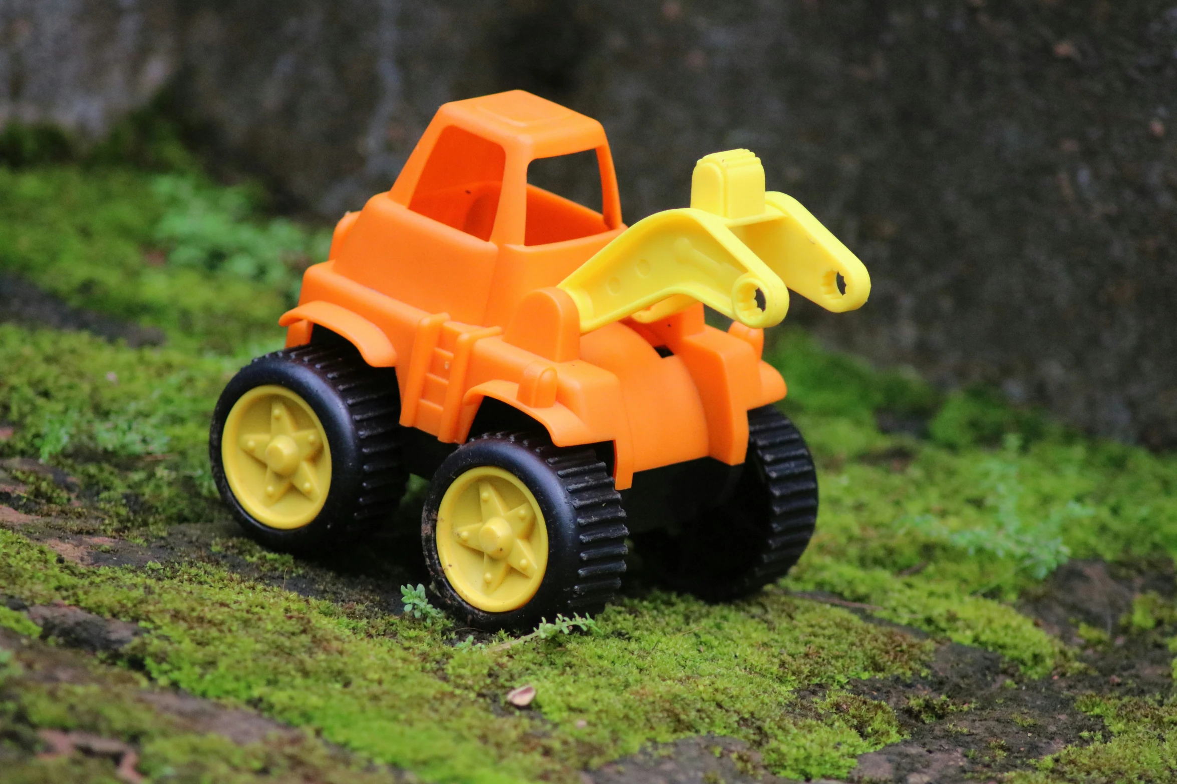 a small plastic toy vehicle driving on grass