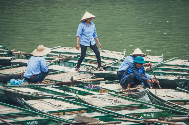 several people in hats are on the boats