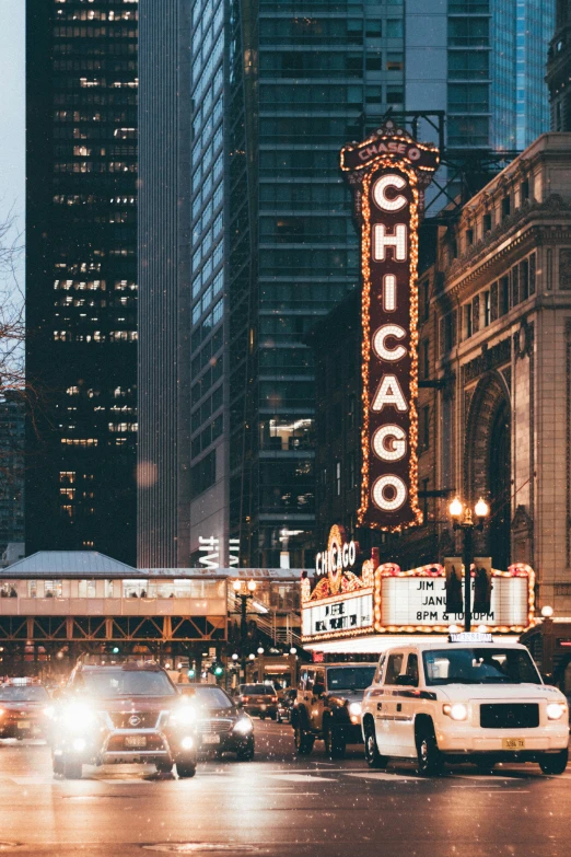 a chicago theatre sign and cars driving on a busy street at night