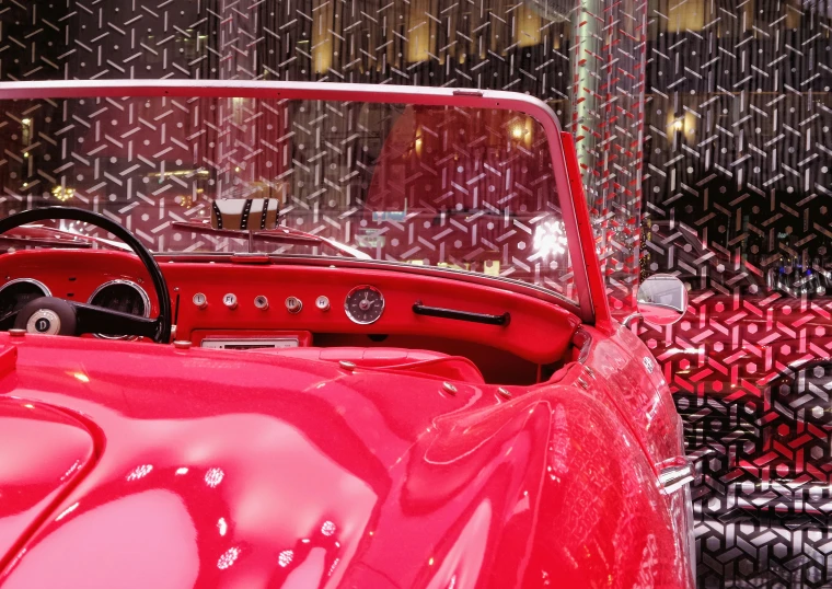 the inside of a pink convertible with black patterned walls