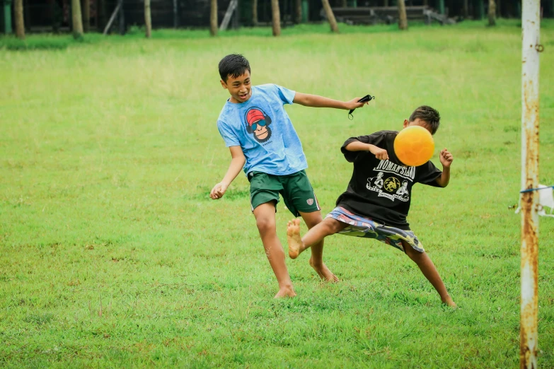 two boys are playing frisbee on the field