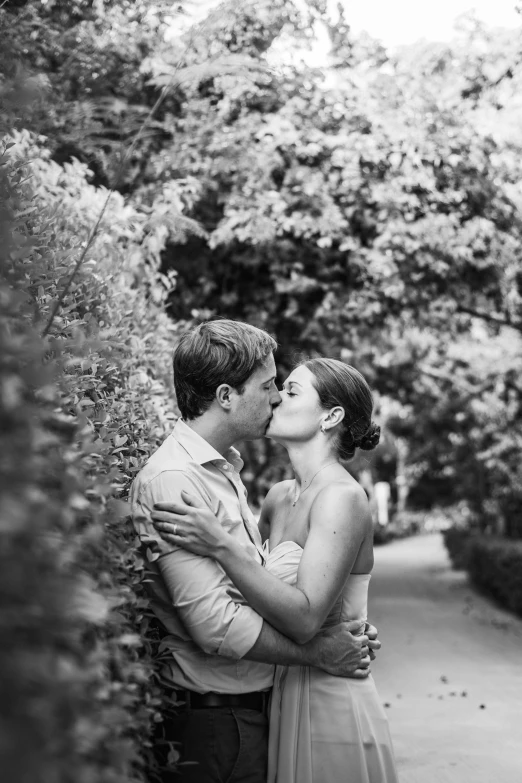 the couple are kissing by the wall on their engagement day