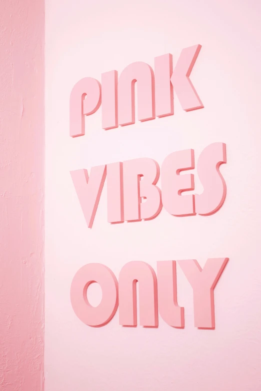 a pink sign on a wall with other pink objects hanging from the wall