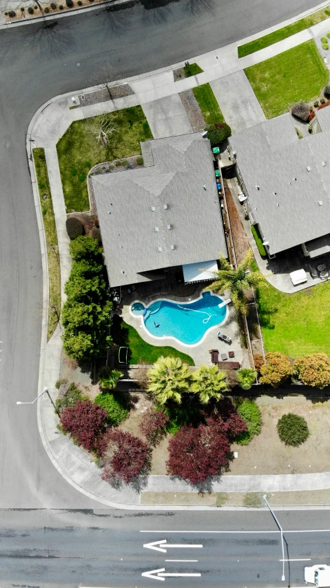 an aerial view of the backyard of a house with a swimming pool