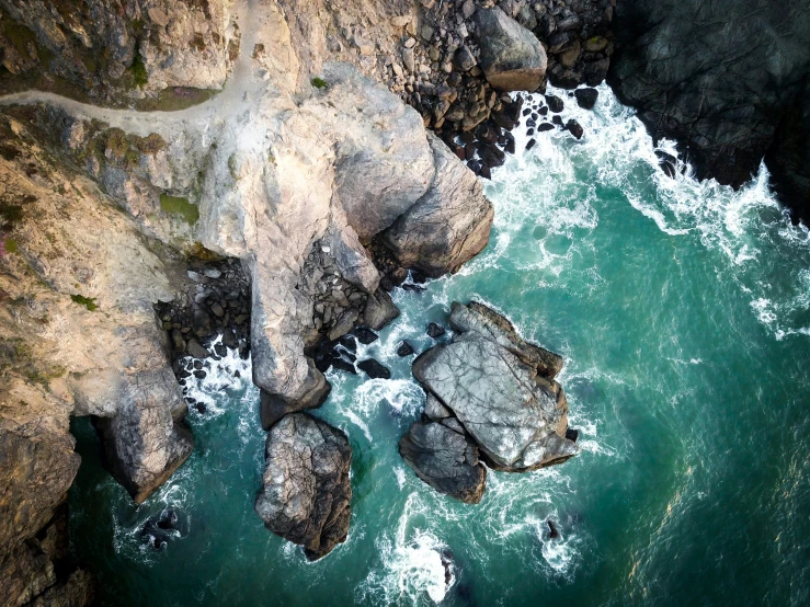 a view from above of some rocks near the ocean