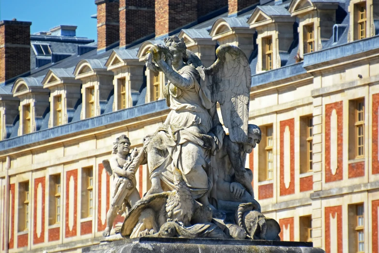 an ancient sculpture in front of a building in the middle of the afternoon