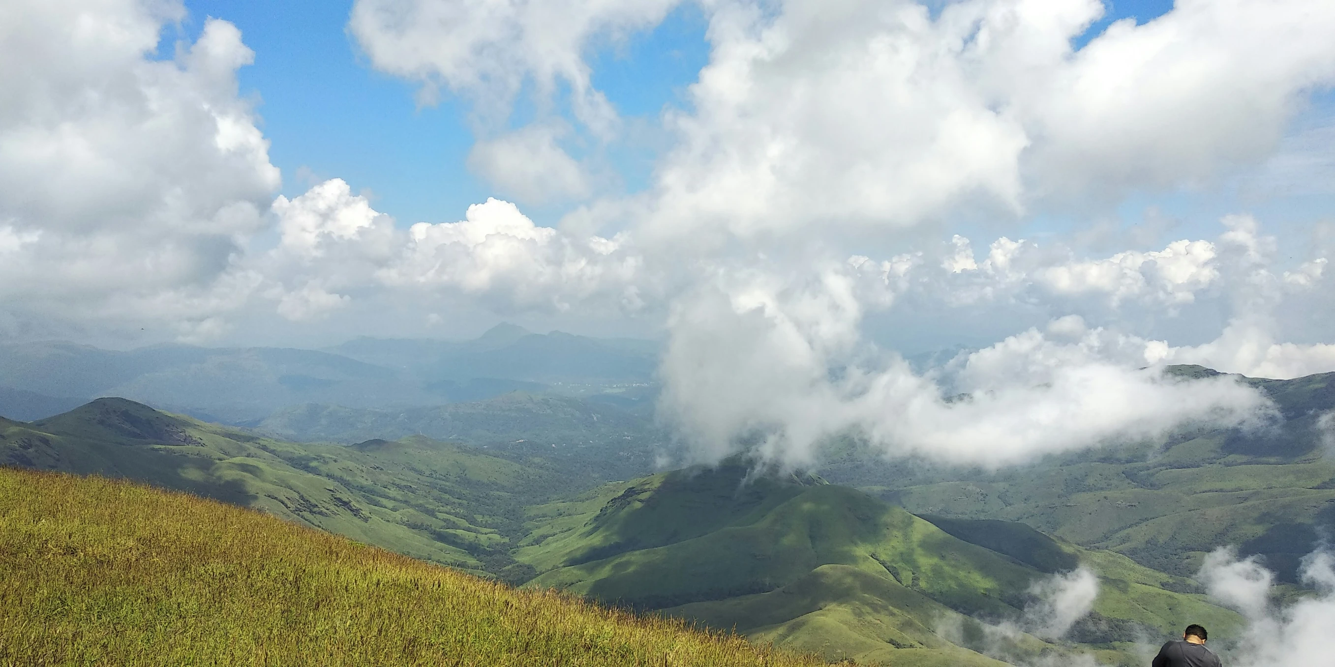 a person sitting on top of a green hill