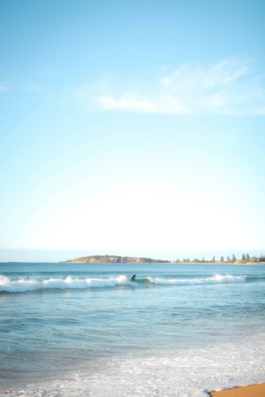 a surfer riding a wave onto the beach