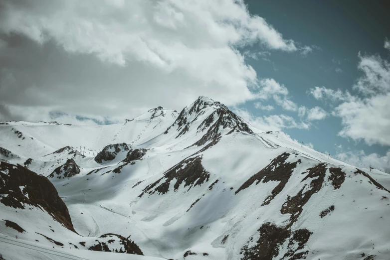 a large snowy mountain with some clouds in it