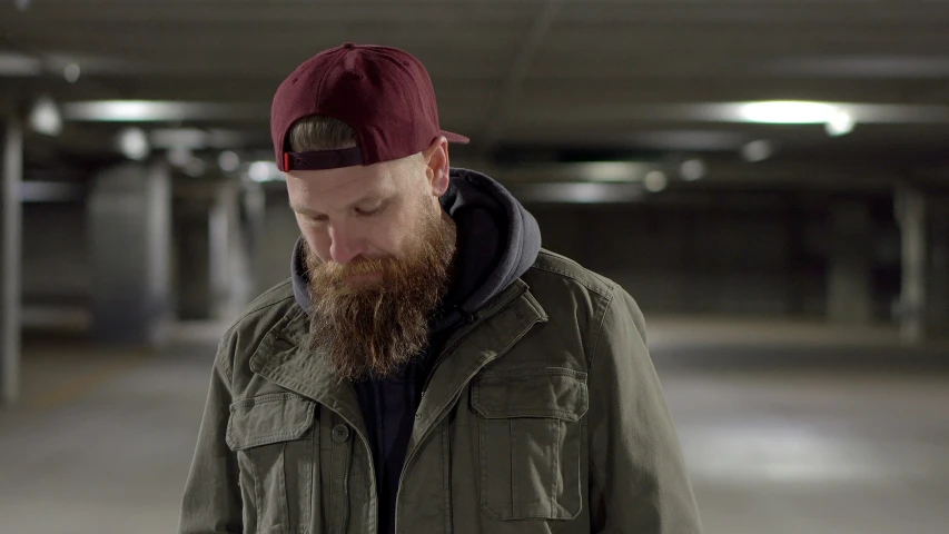 a bearded man looks down at his phone