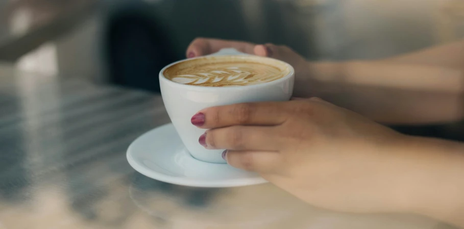 a person is holding a cup and saucer