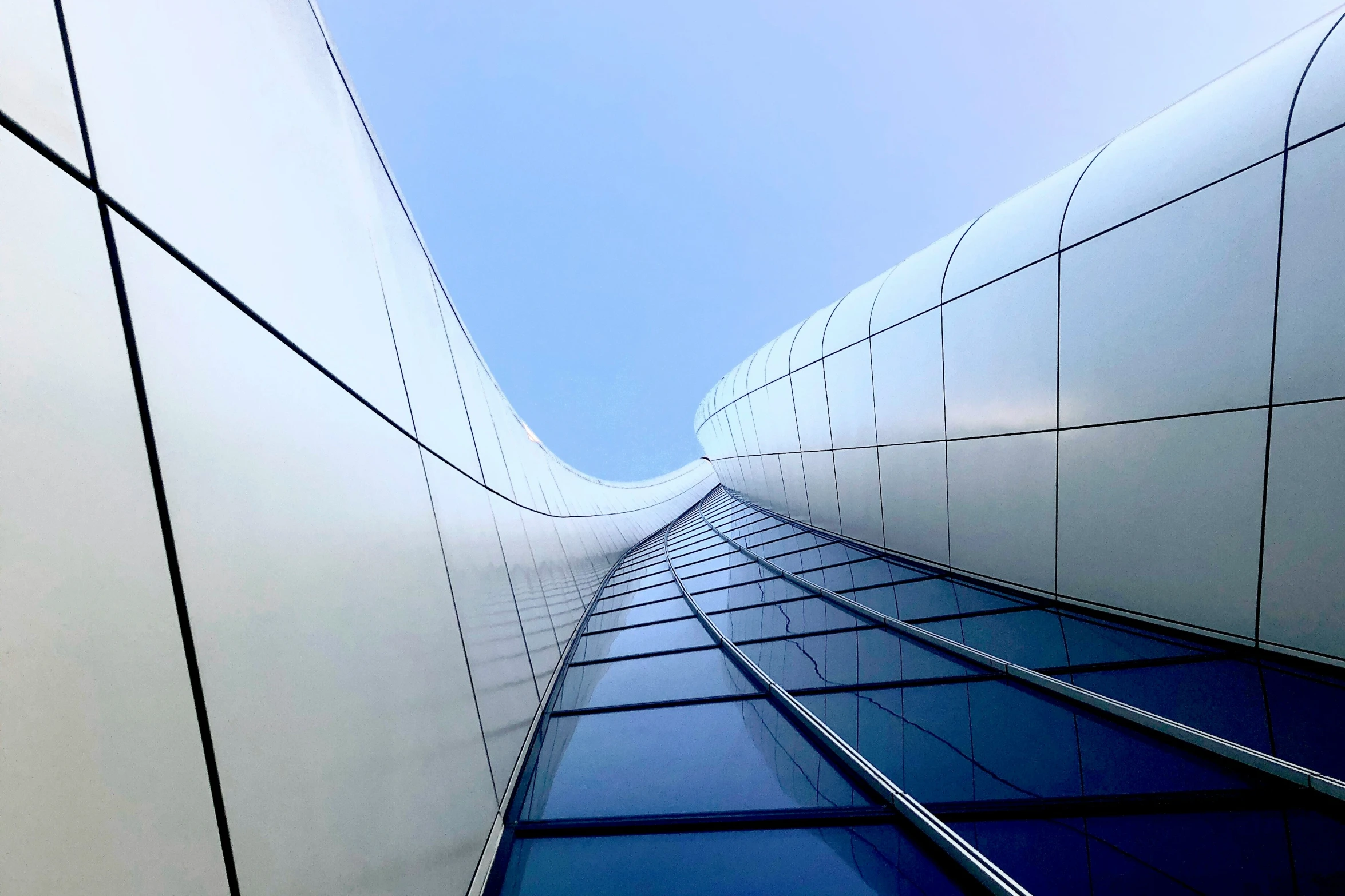 the underside of a white building with blue sky in the background