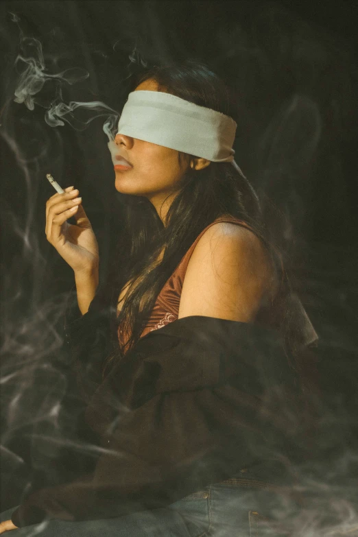 a woman with headband smoking a cigarette in smoke