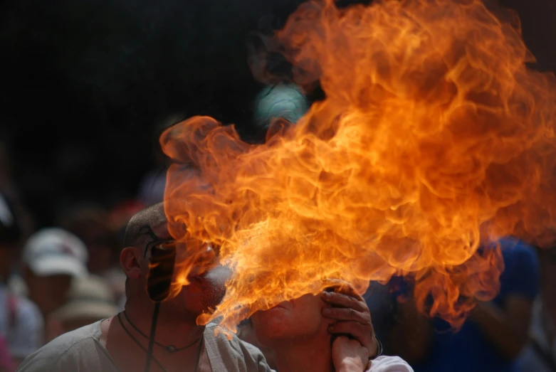 a man is holding his face near fire