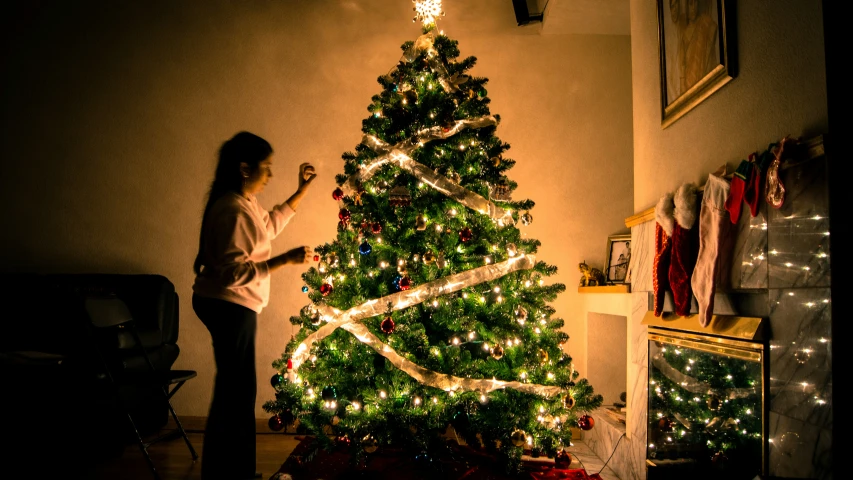 woman measuring the length of a christmas tree