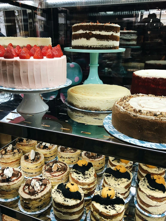 an assortment of deserts on display in a pastry shop
