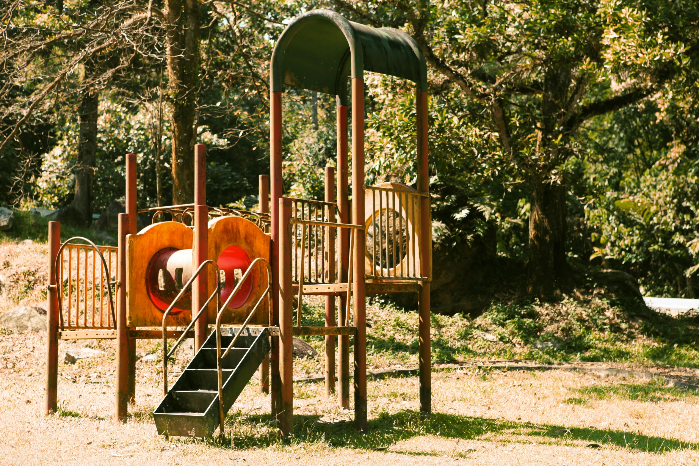 there is an empty playground with wooden slides and climbing frames