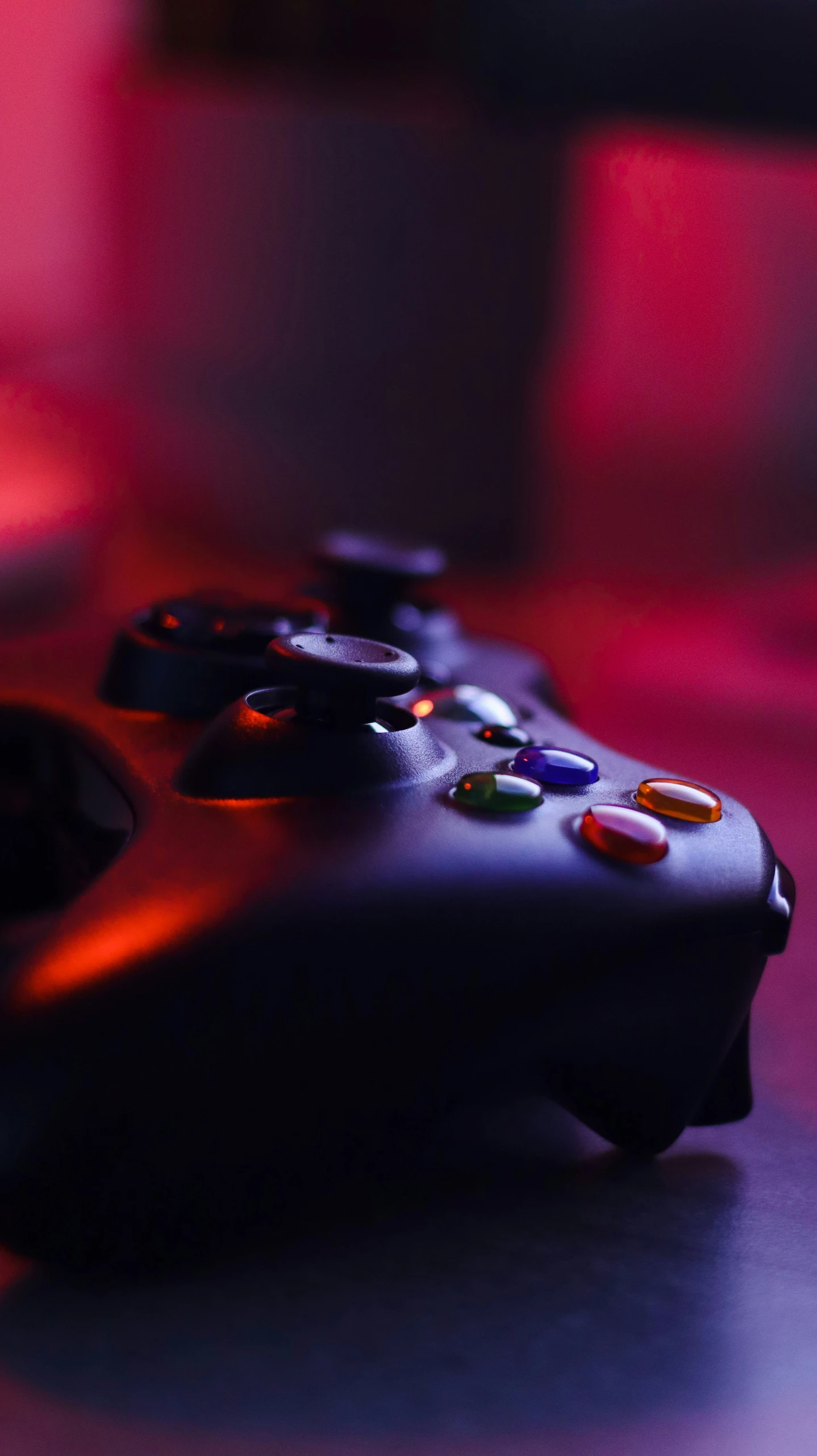 two controllers on a table with red lighting