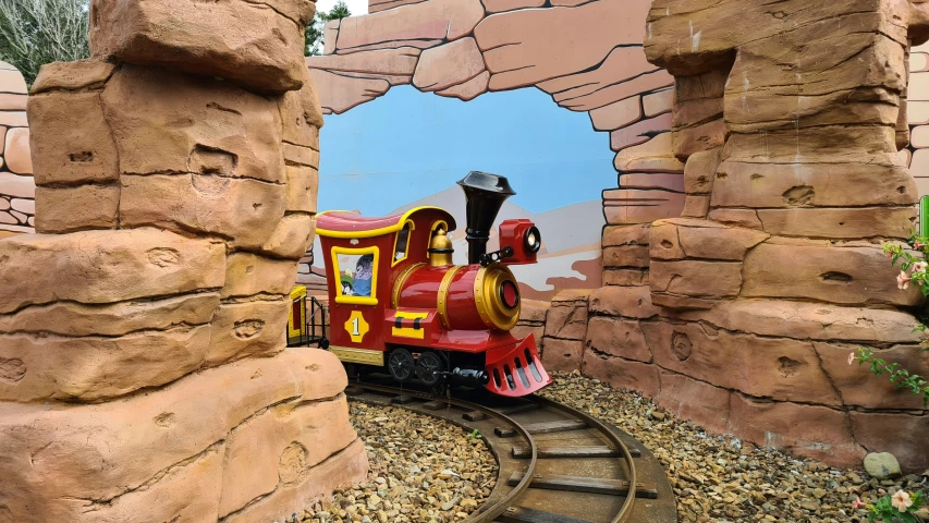 a small toy train is going through the tunnel