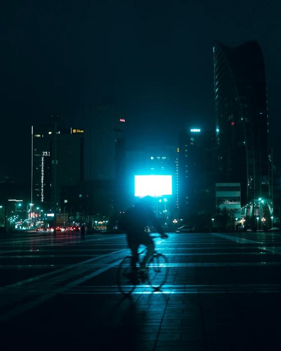 a man riding a bike through a dark city street