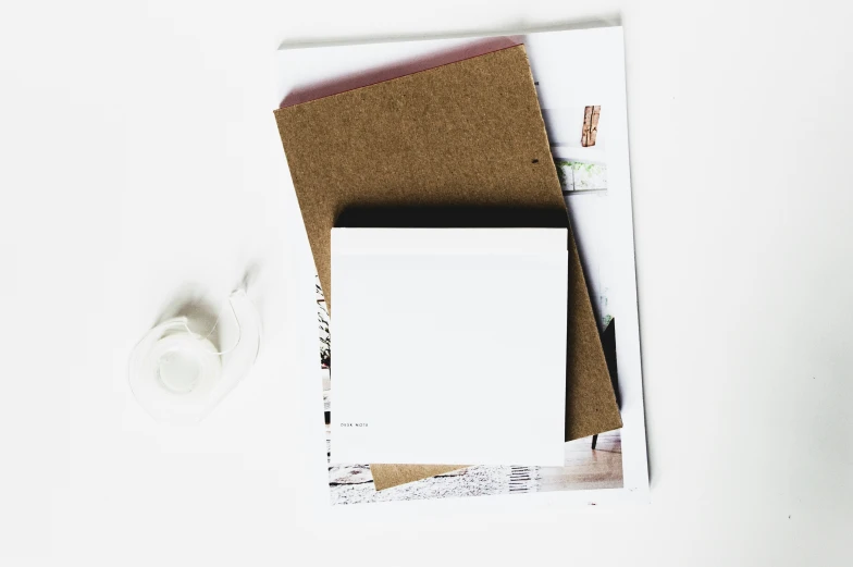 white envelope with blank paper on top and a paper tape