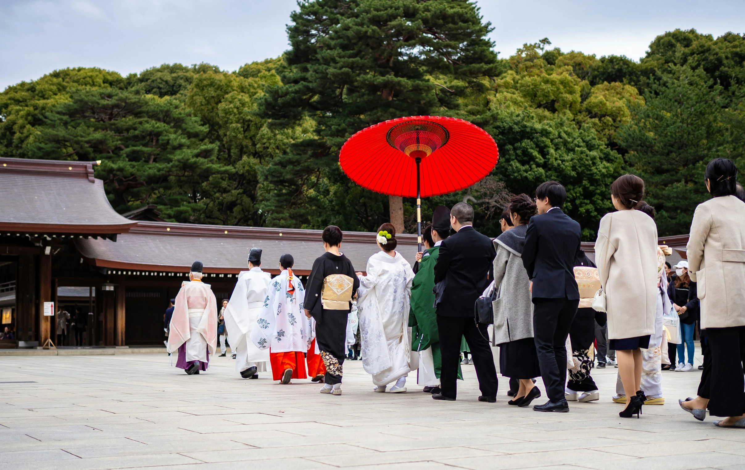 people standing in the middle of a courtyard and walking with umbrellas