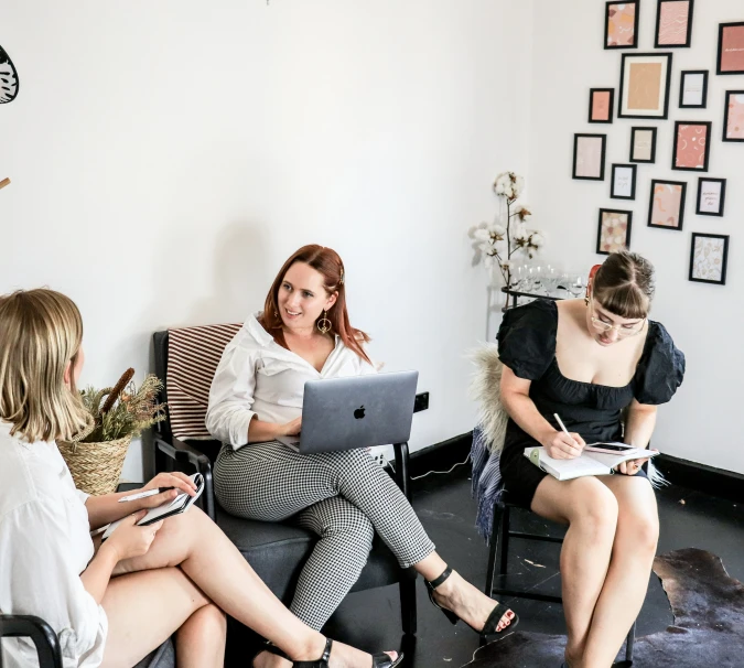 a group of women sitting in chairs around each other