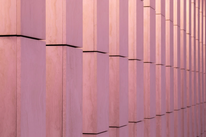 a person walks past a colorful wall of vertical purple lines