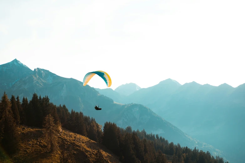 two people are flying kites on top of a mountain