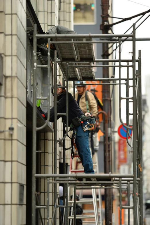 a person on a scaffold working on a city street