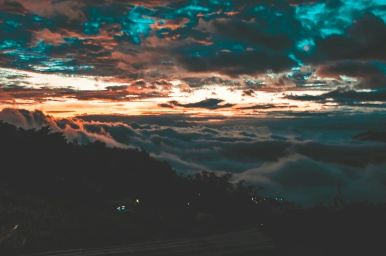 an evening cloudy view of an ocean or cloud with trees