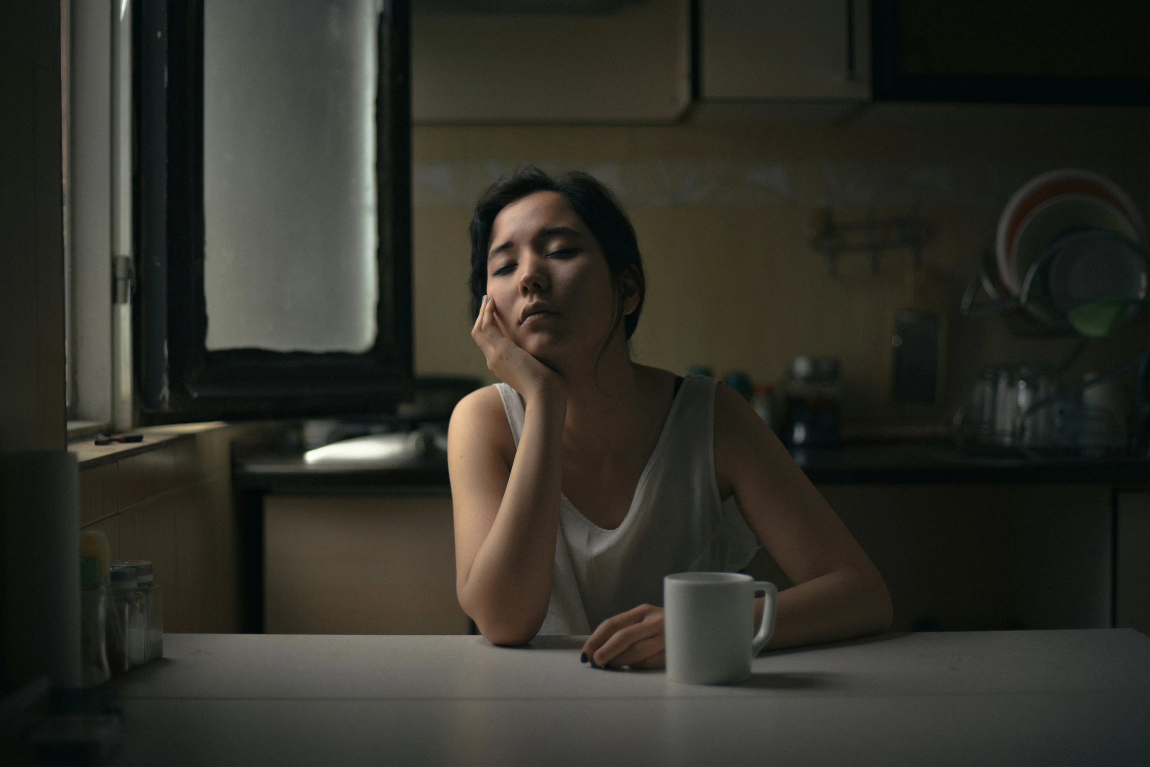 a woman sitting at a table with a coffee cup