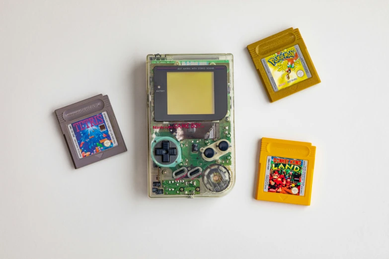 a nintendo game boy on a phone with some nintendo gameboy toys next to it