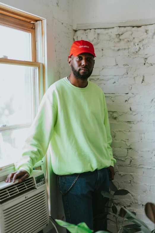 a black man wearing a bright green shirt and a baseball cap