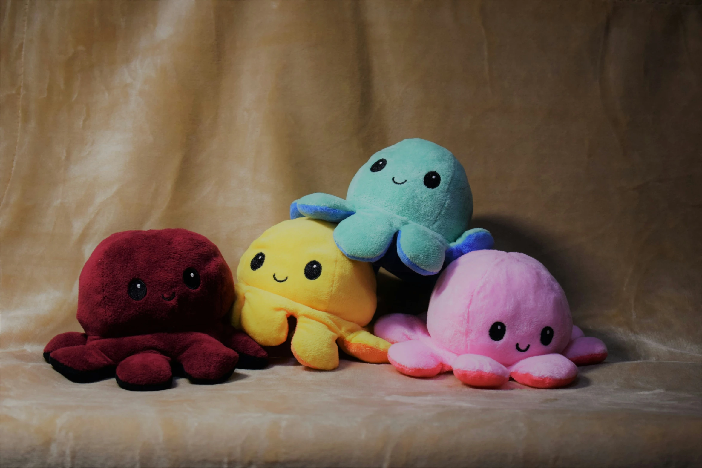 six stuffed animal toys in the shape of small octoes