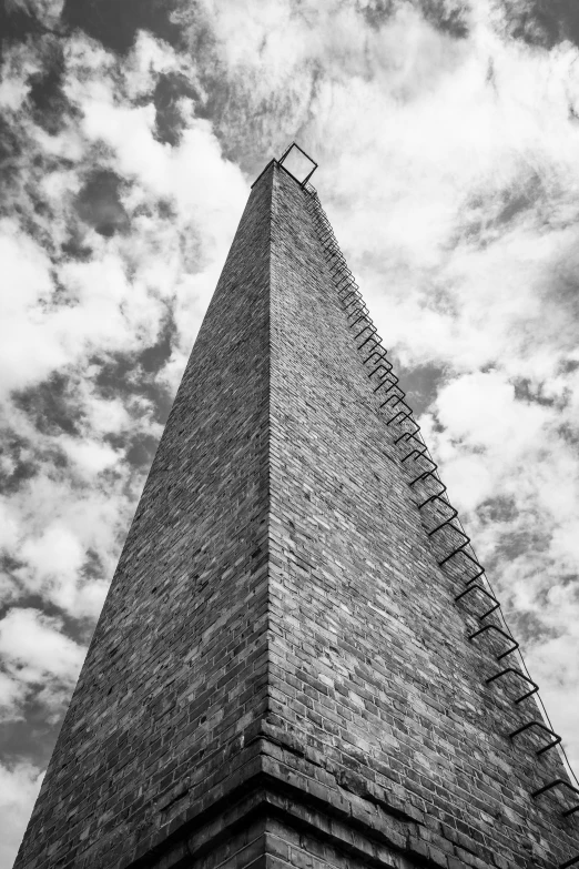 an upward s of a steeple with clouds in the background