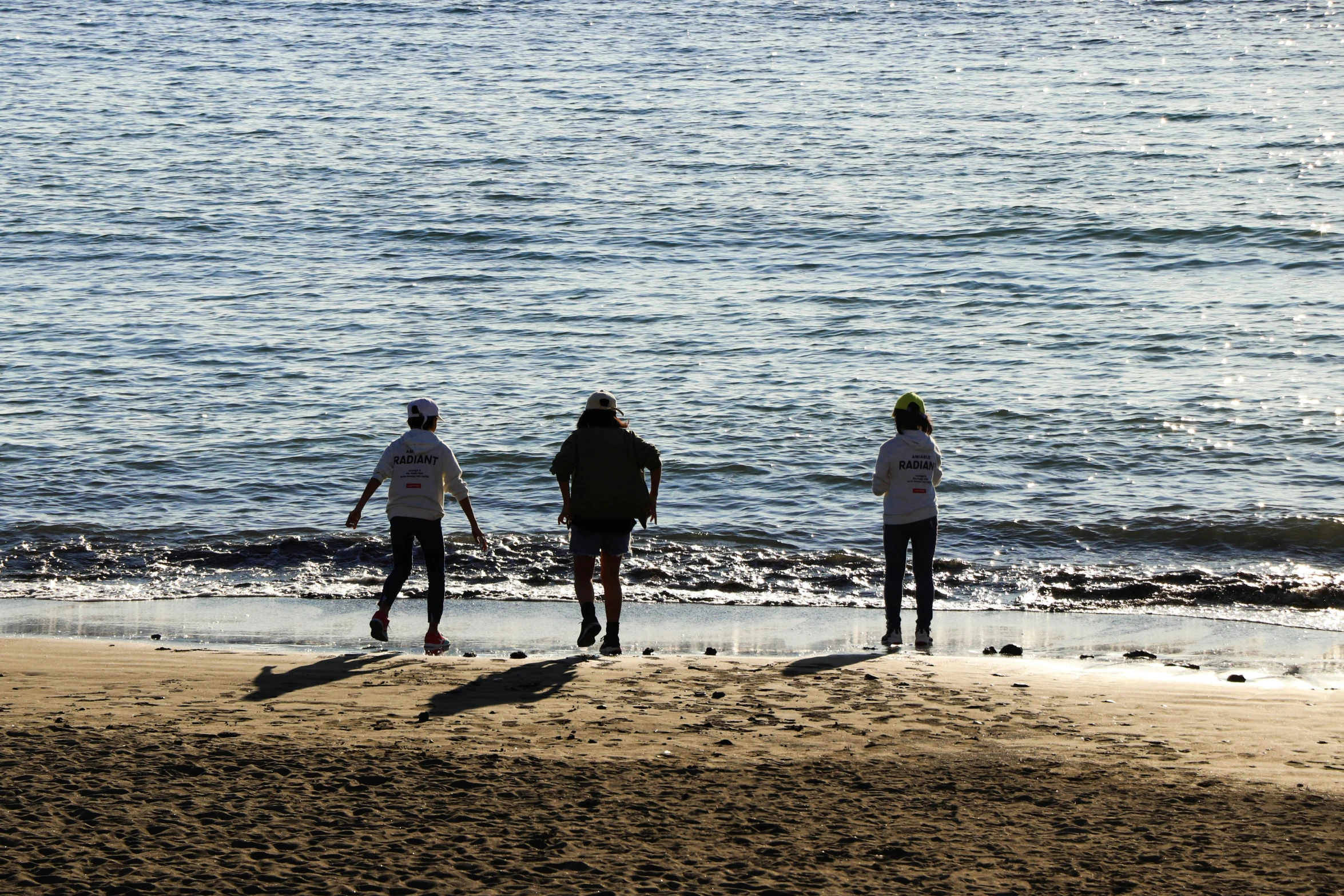 three people at the beach with their surfboards