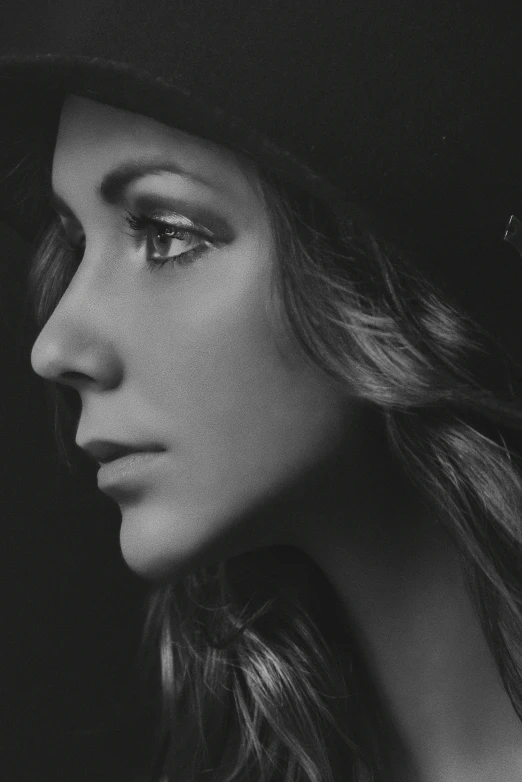 a black and white po of a woman wearing a hat