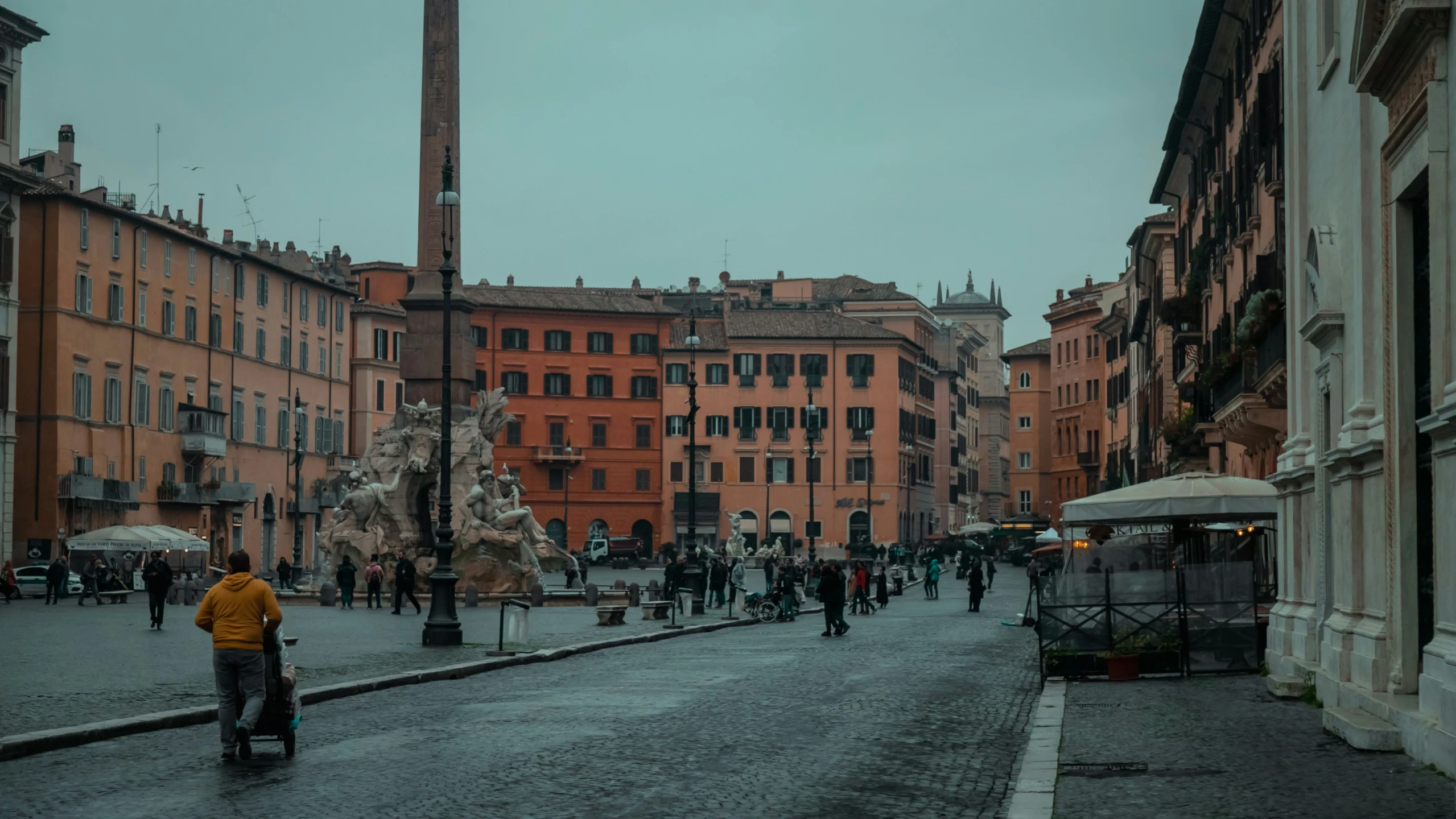 people walking around in an old - town square with tall buildings