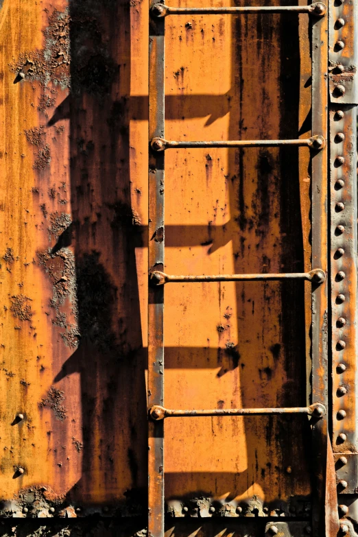the side of an old rusty train with paint peeling off
