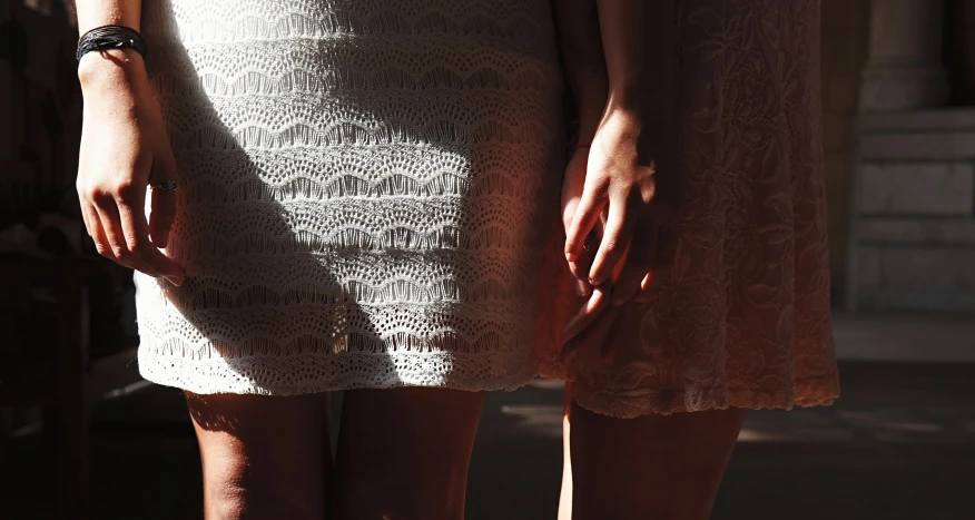 a close - up of the legs of two women in white dresses
