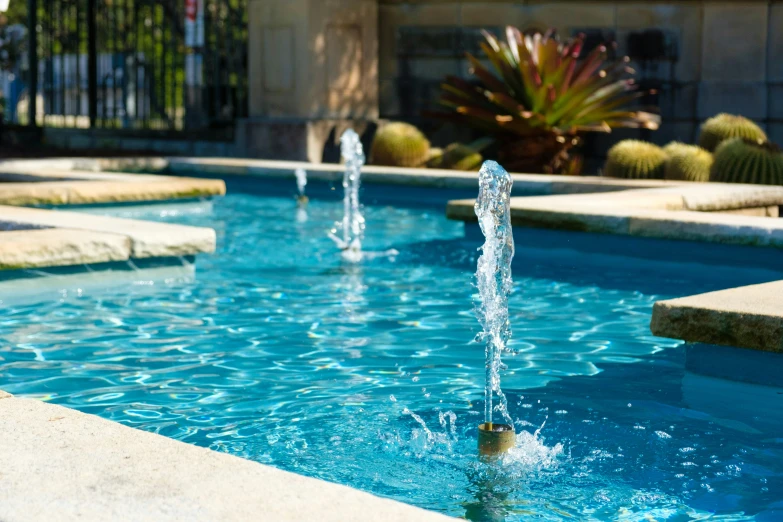 a fountain is located in a backyard pool