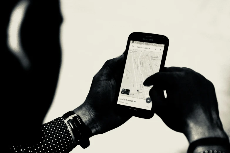 a person holding a cell phone in front of a white background