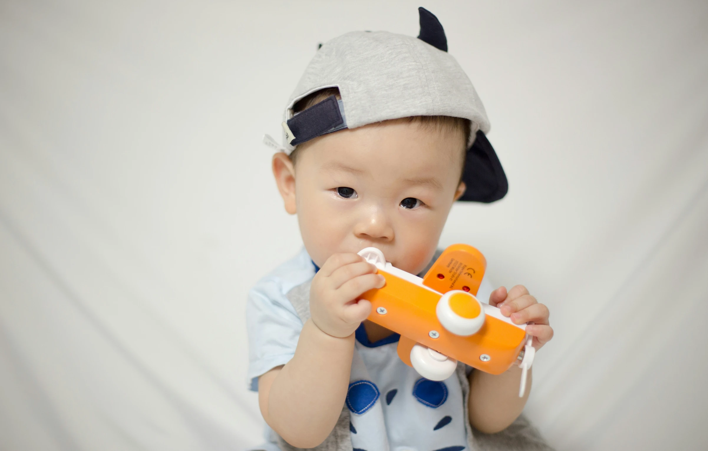 a baby wearing an airplane hat with a toy in it