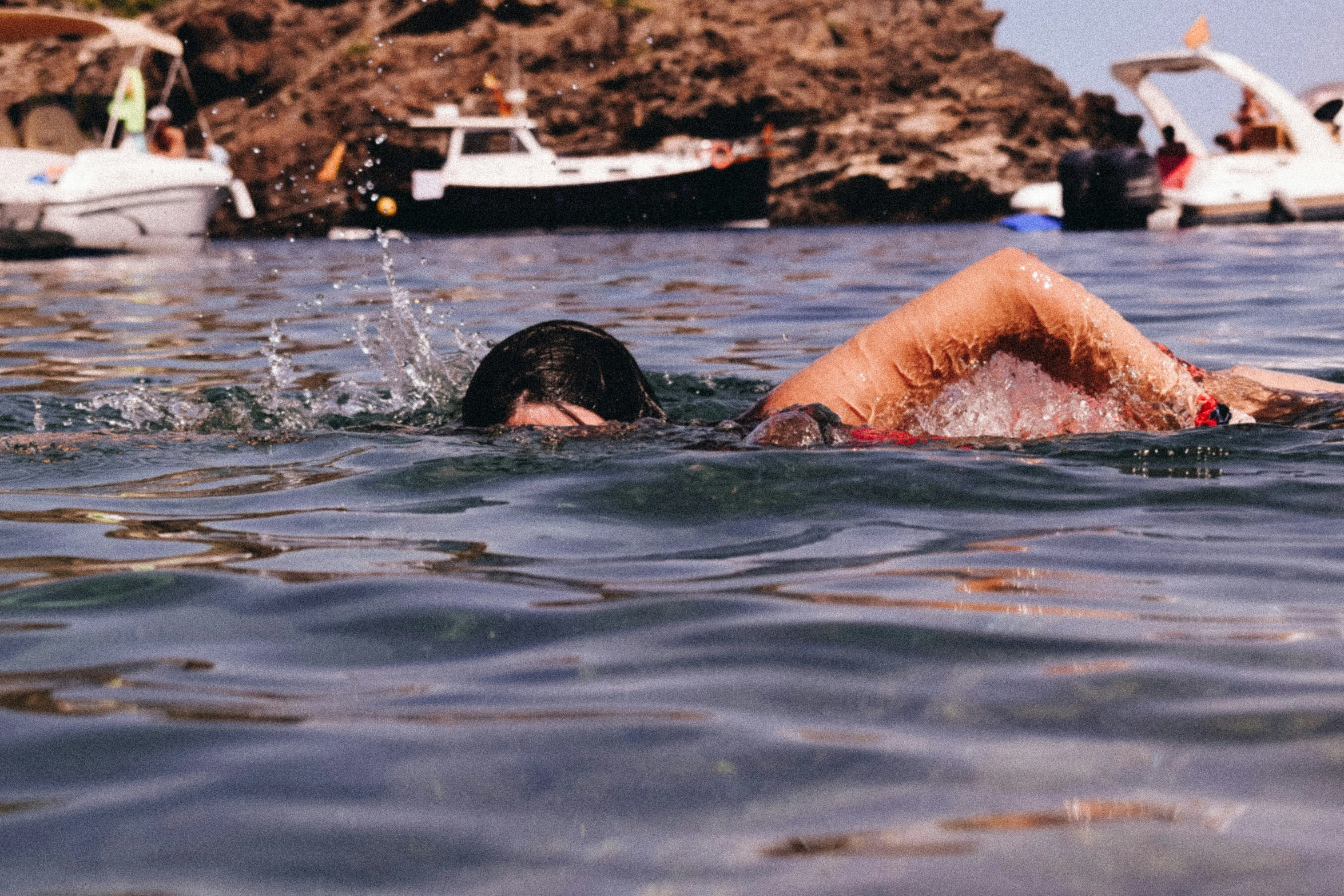 a man swimming on his stomach in a body of water