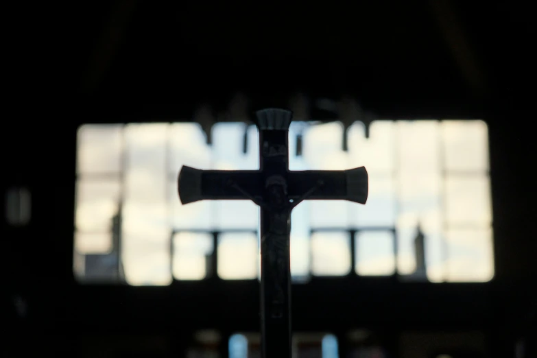 the cross is on a table by an open window