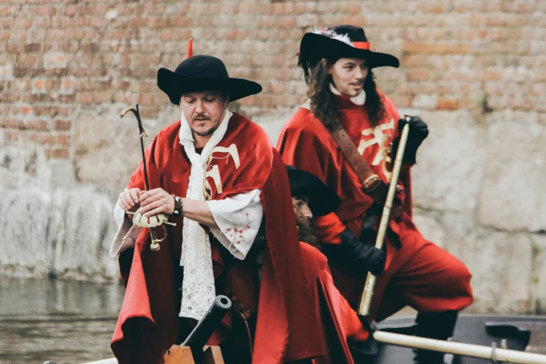 two men in red and black outfit on a boat